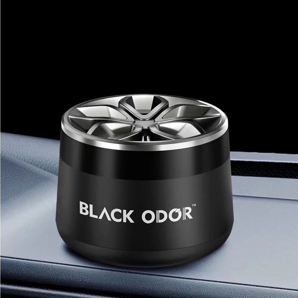 Black Odor car air freshener on a car dashboard with a black background