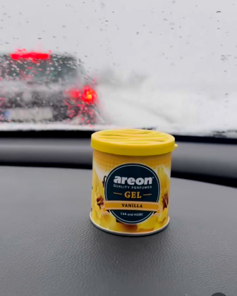 Areon Smoothie Gel container on a car dashboard with a snowy road background