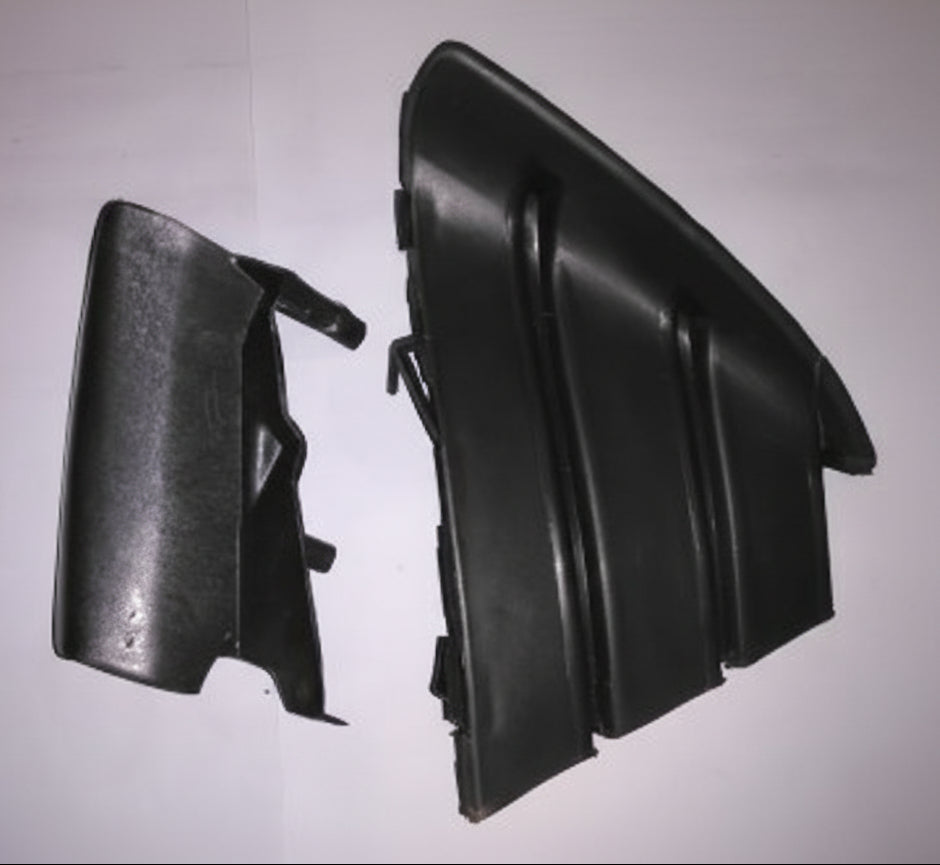 Two black plastic car interior parts on a light gray background