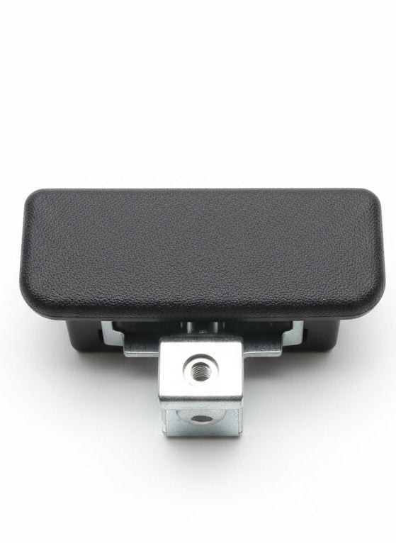 Black textured object with a metallic component on a wooden surface