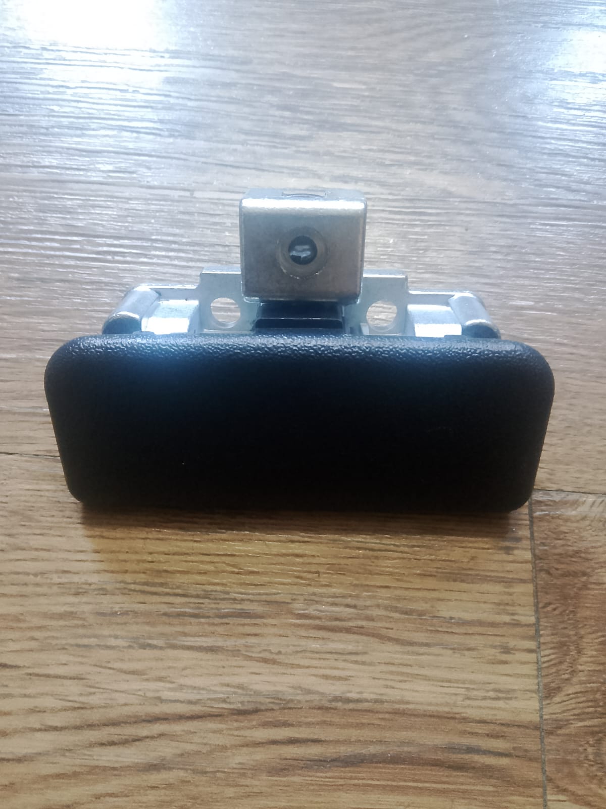 Black office chair armrest on a wooden floor