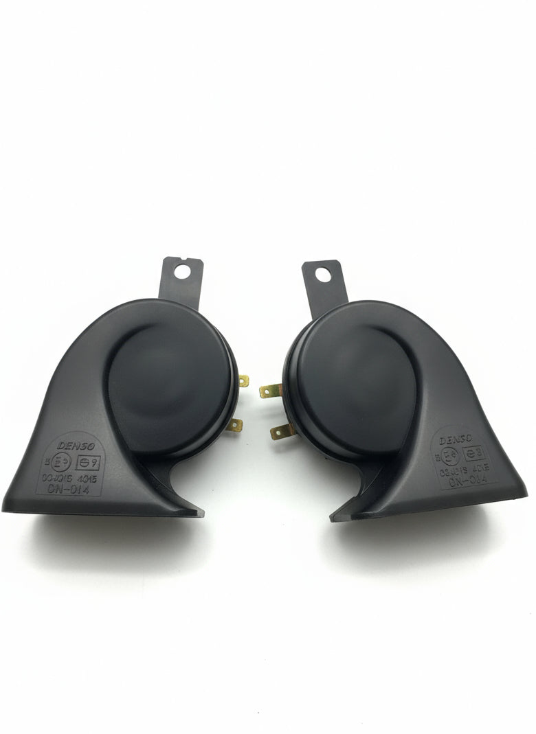 Two black horn devices on a wooden surface