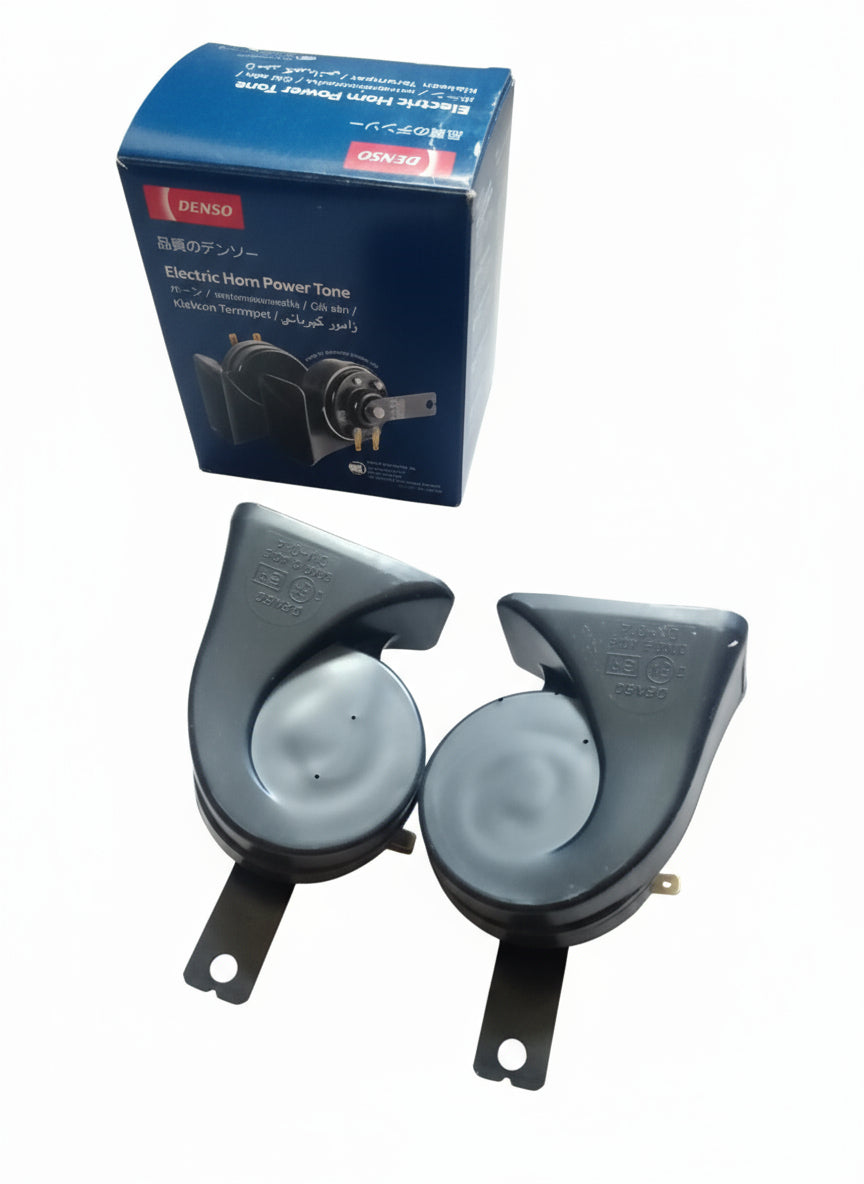 Two electric horns and their packaging on a wooden surface