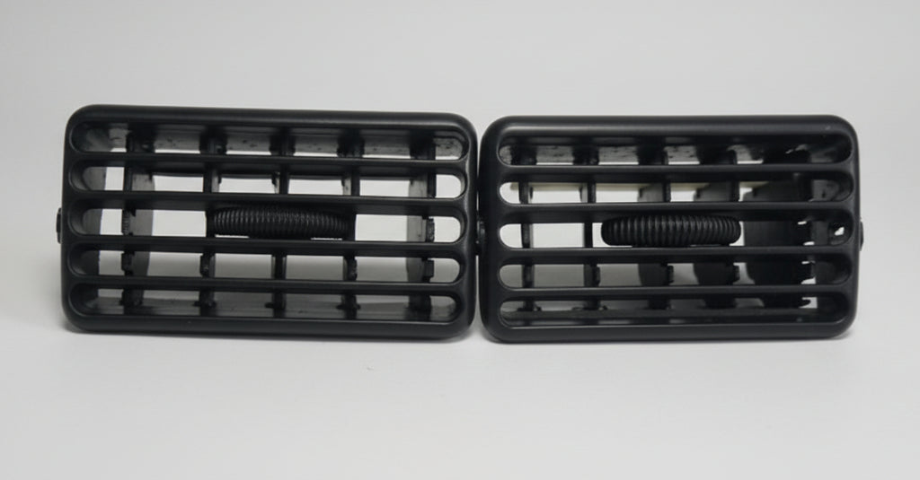 Two black car grills on a light gray background