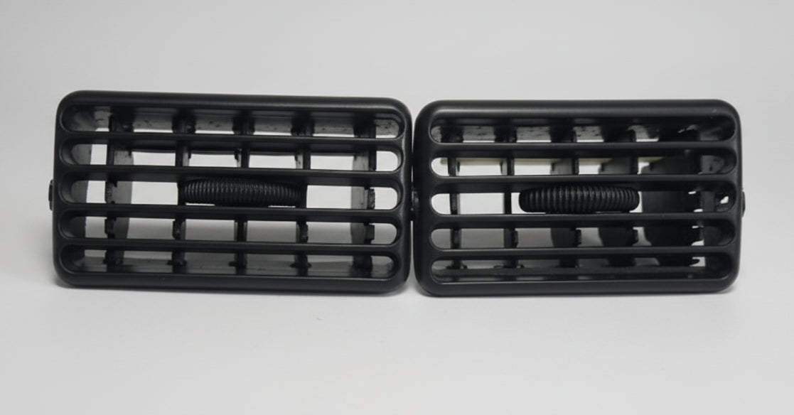 Two black car grills on a light gray background