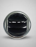 Close-up of a car air vent with a metallic rim on a textured surface.