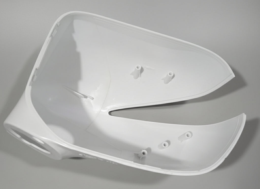 White plastic car part on a textured gray surface