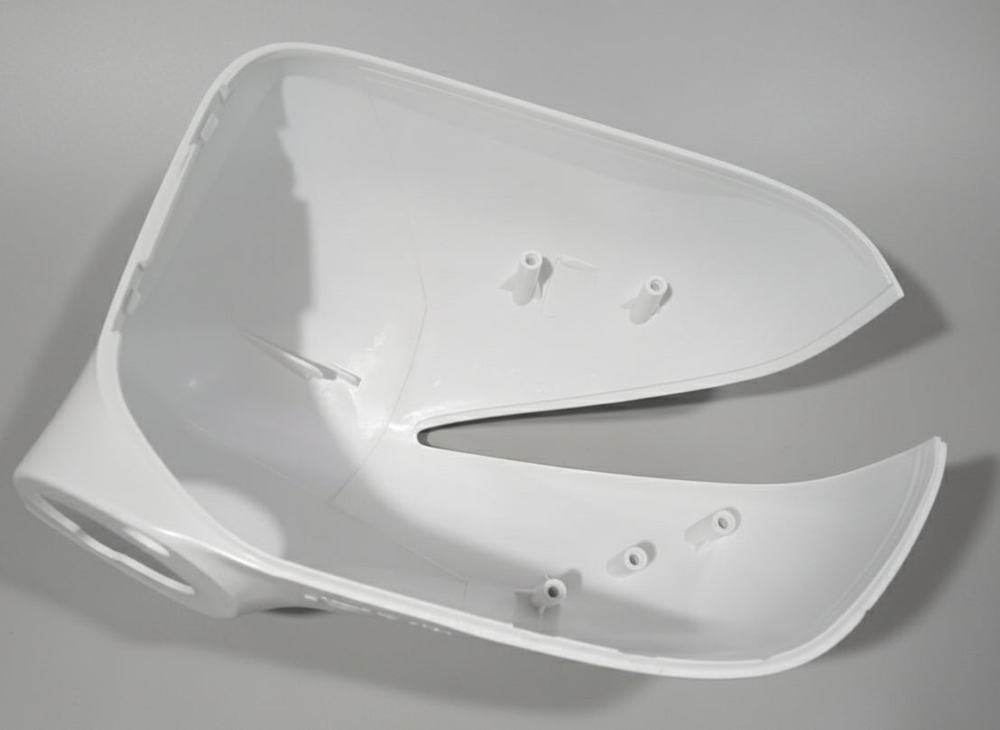 White plastic car part on a textured gray surface