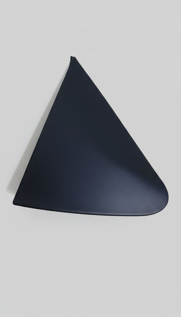 Black plastic car mirror cover on a cardboard surface