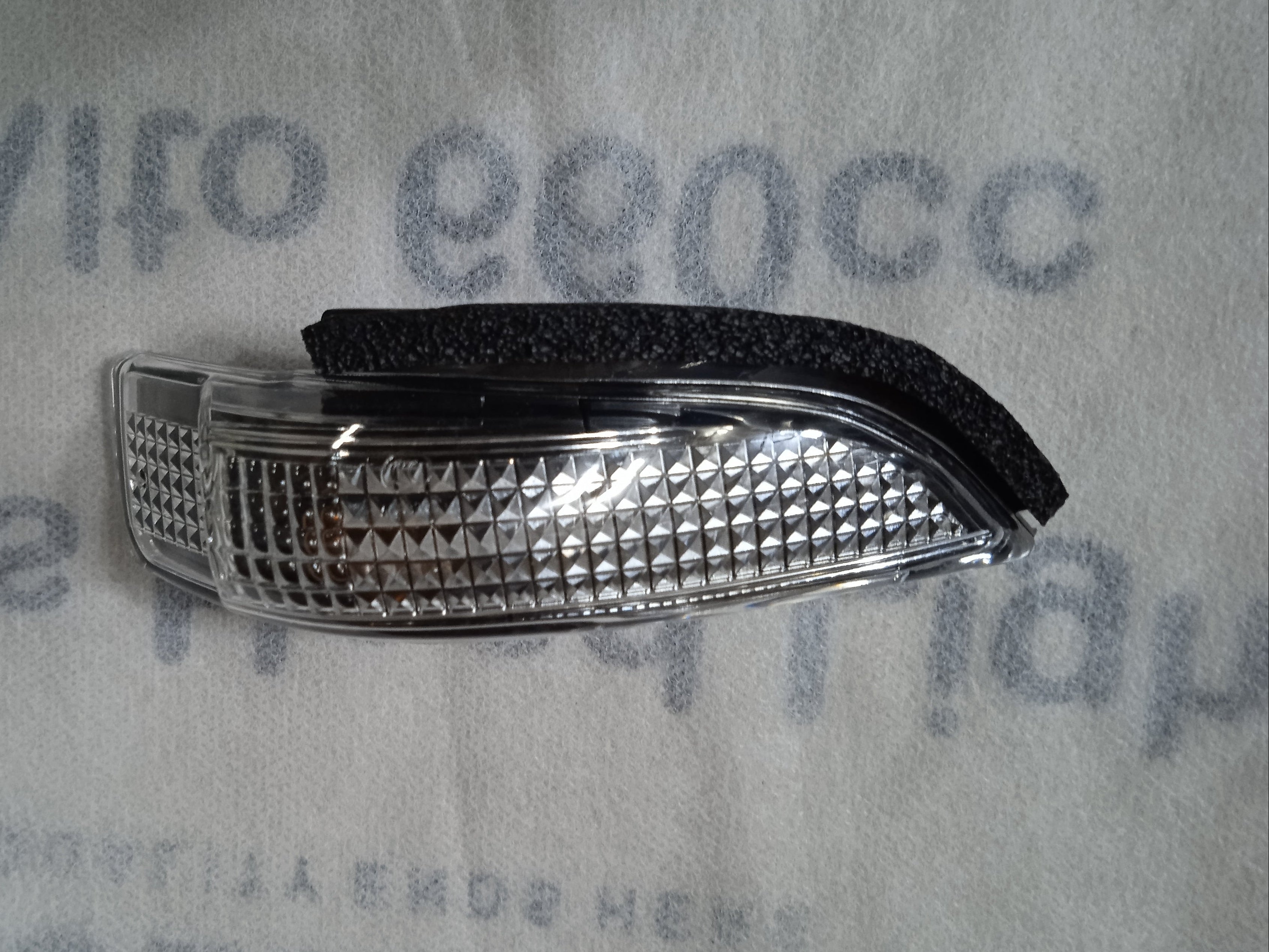 Car fog light cover on a textured gray background