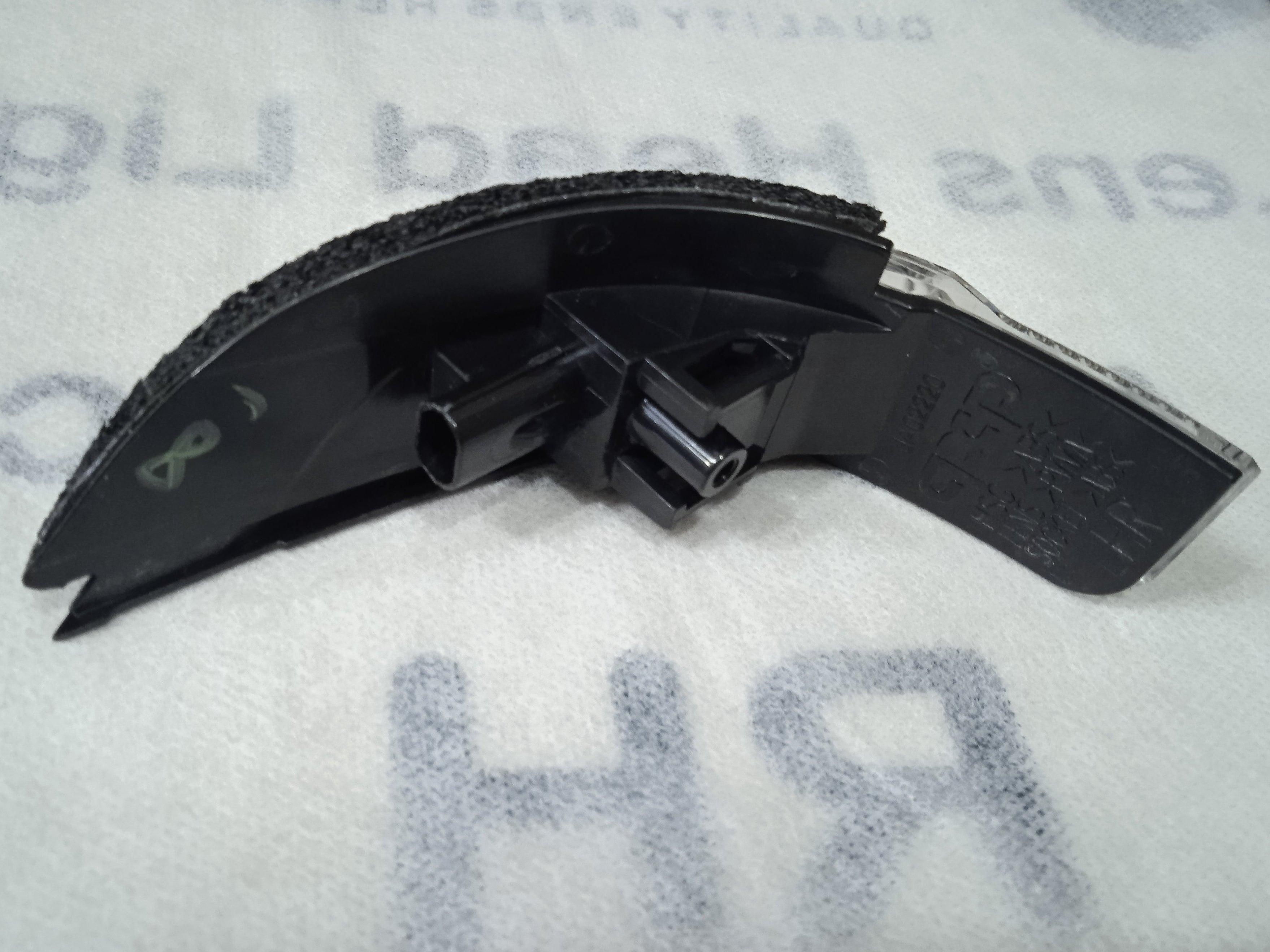 Car windshield wiper blade on a white surface with text