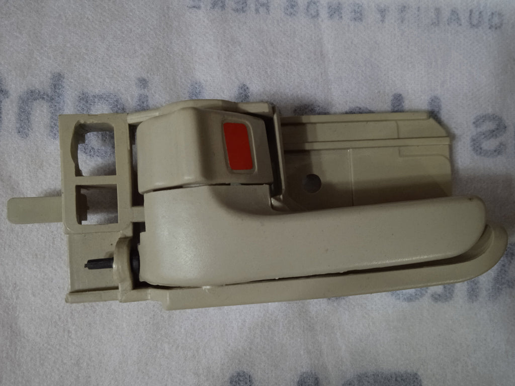 Beige window handle on a textured surface with text