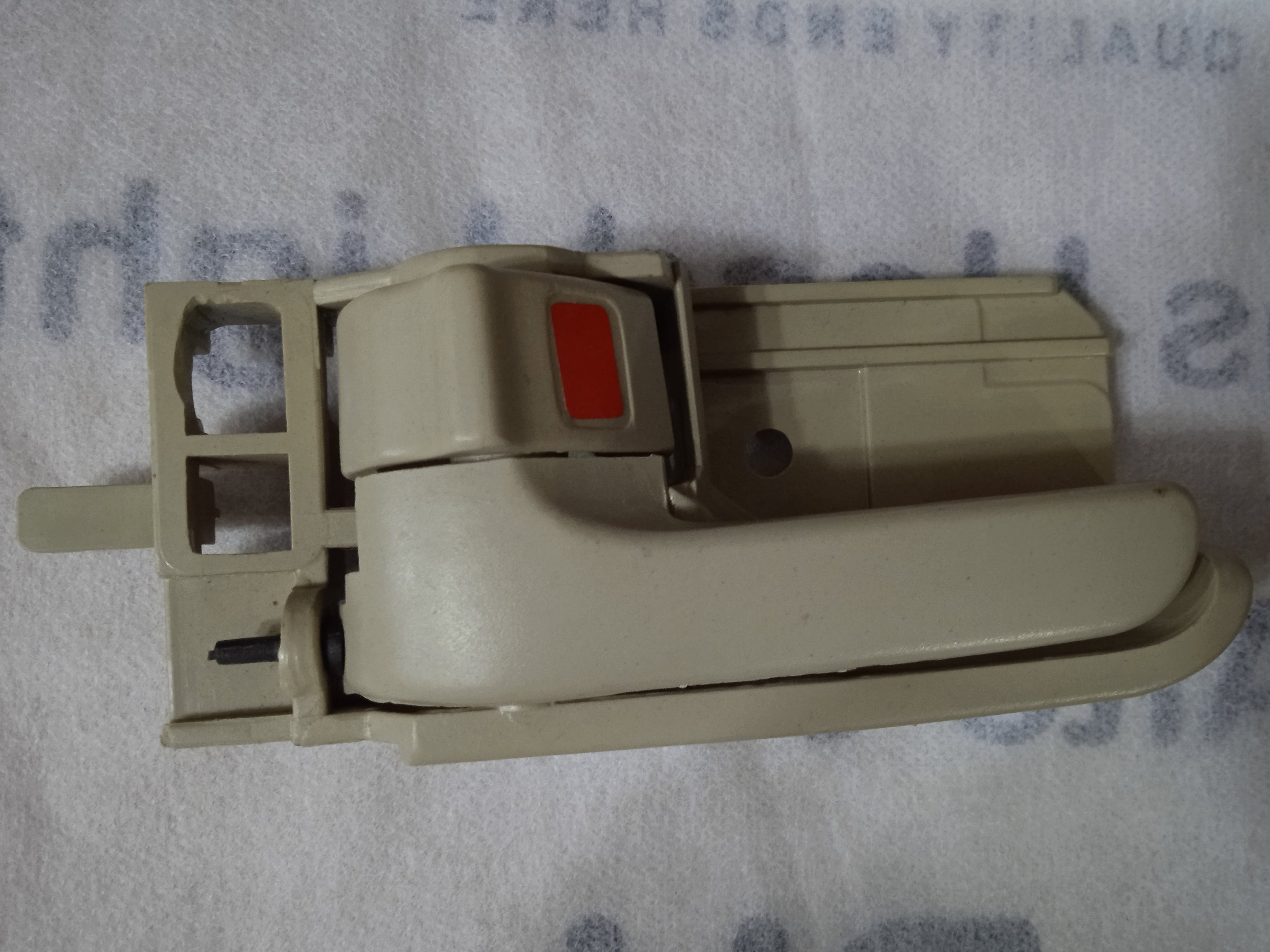 Beige window handle on a textured surface with text