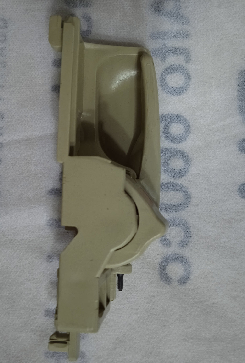 Beige car door handle on a gray background with text