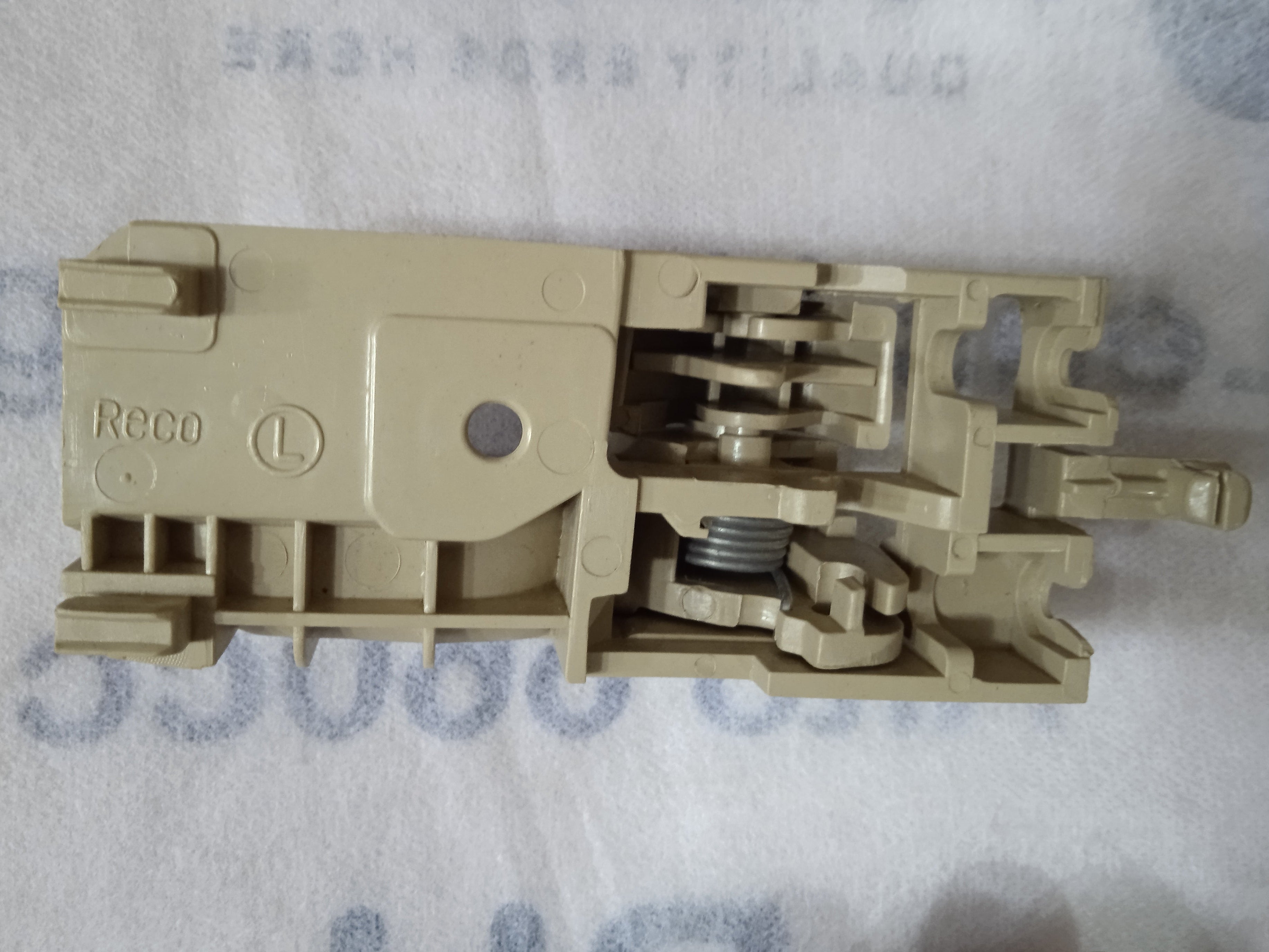 Beige electrical switch or connector on a textured white background