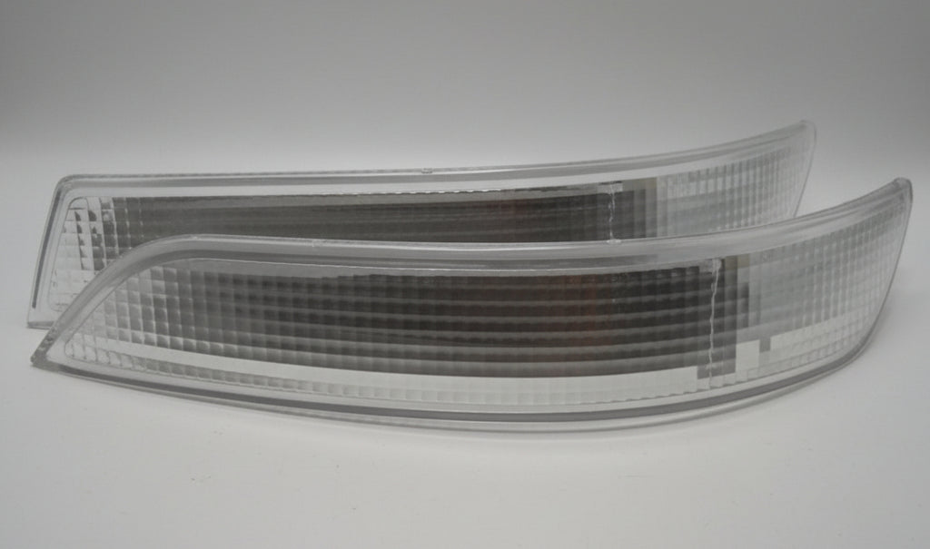 Car headlight on a white surface with cardboard box in the background