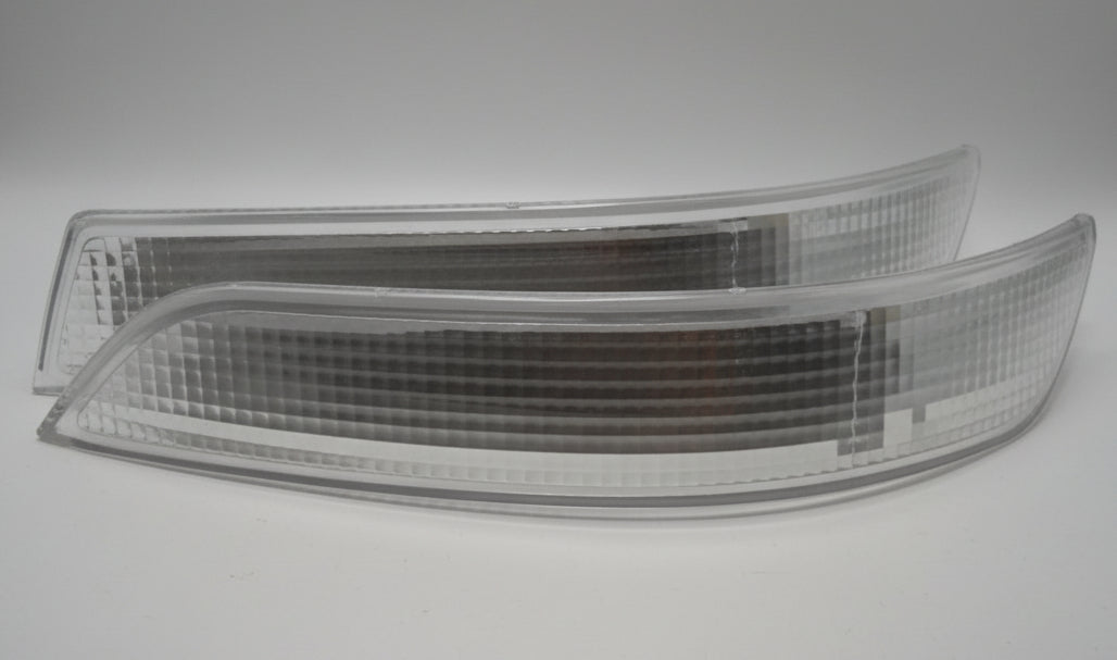 Car headlight on a white surface with cardboard box in the background