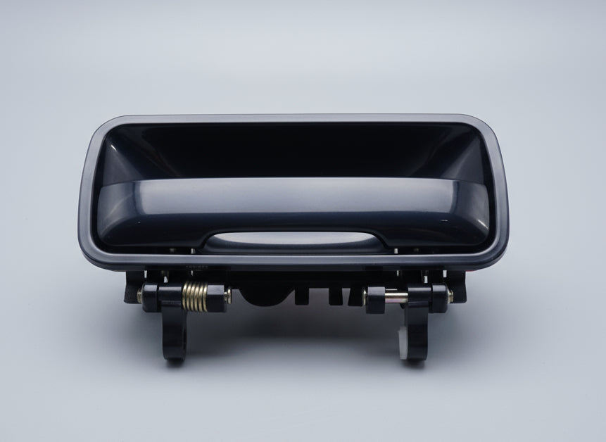 Black car exterior door handle on a beige background