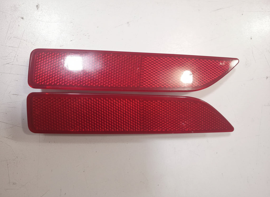 Two red reflective strips on a white surface