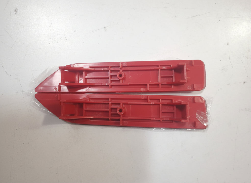Two red plastic parts on a white surface