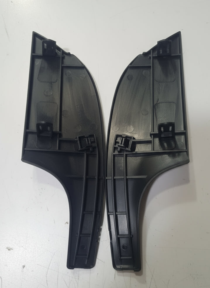 Two black plastic car window wiper blades on a white surface