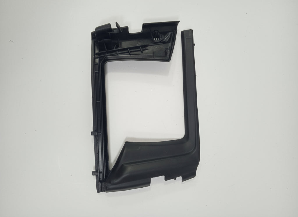 Black plastic car part on a white surface