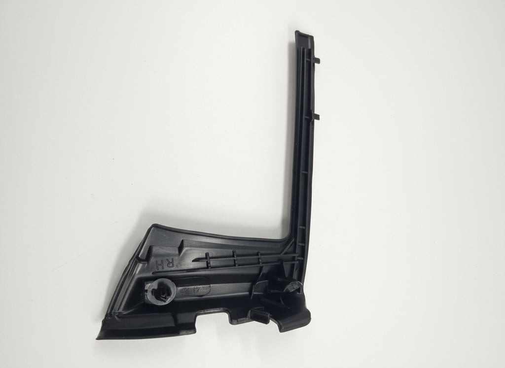 Black plastic car part on a white surface