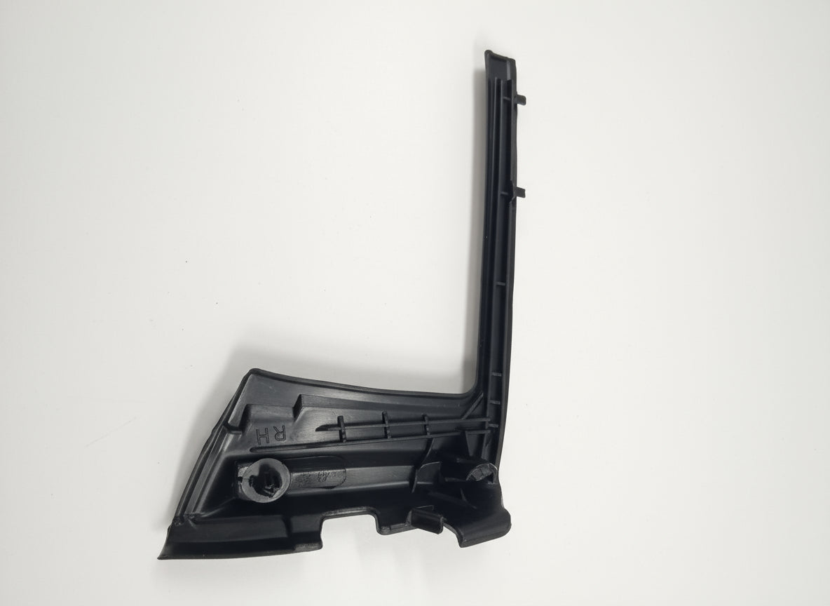 Black plastic car part on a white surface