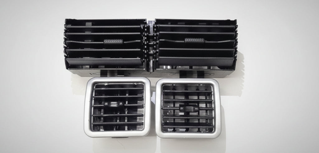 Set of black and silver air vents on a white surface