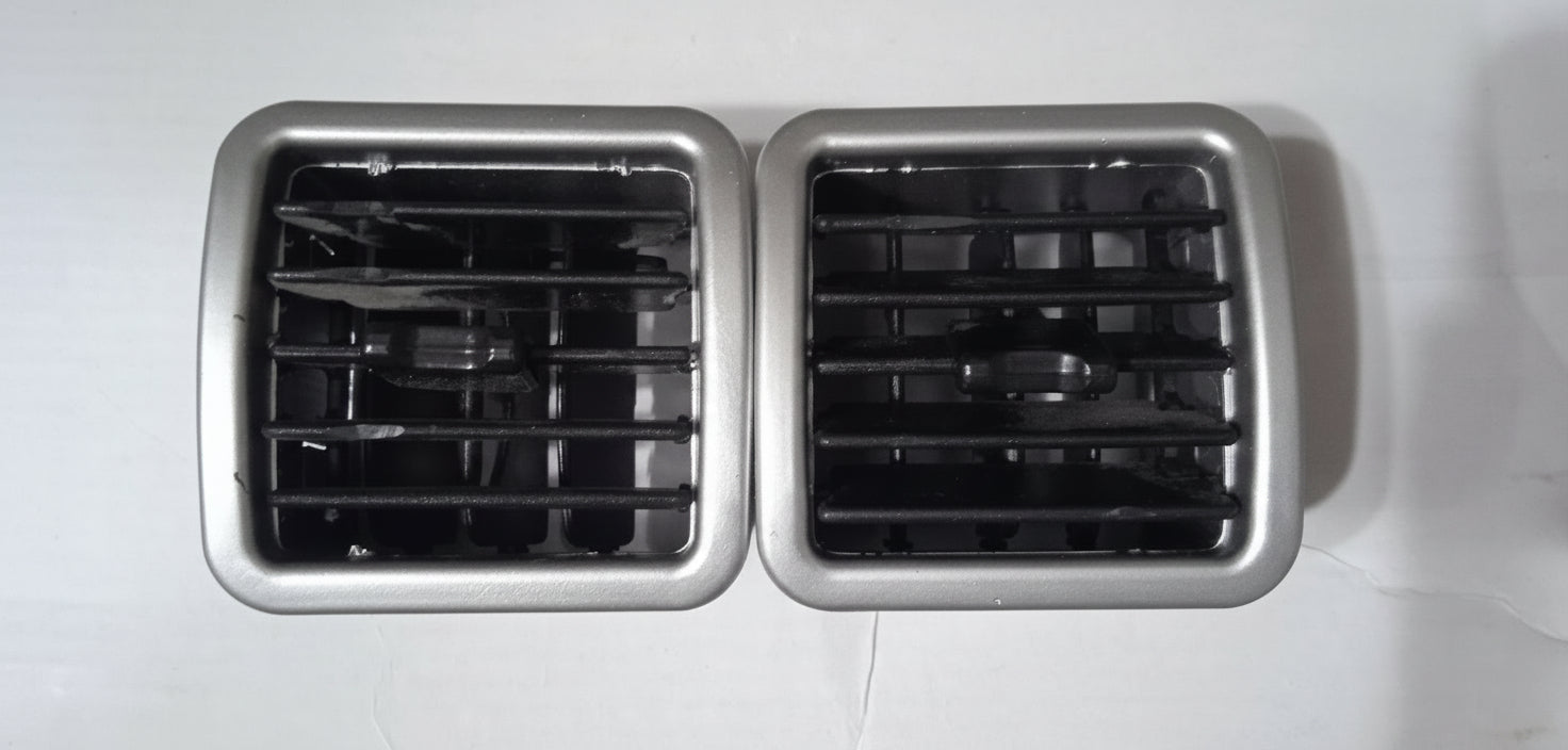 Two metallic air vent grilles on a white background