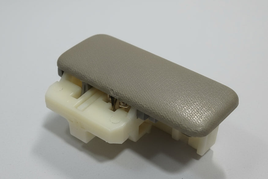 Car interior armrest cover with beige and white components on a light gray background