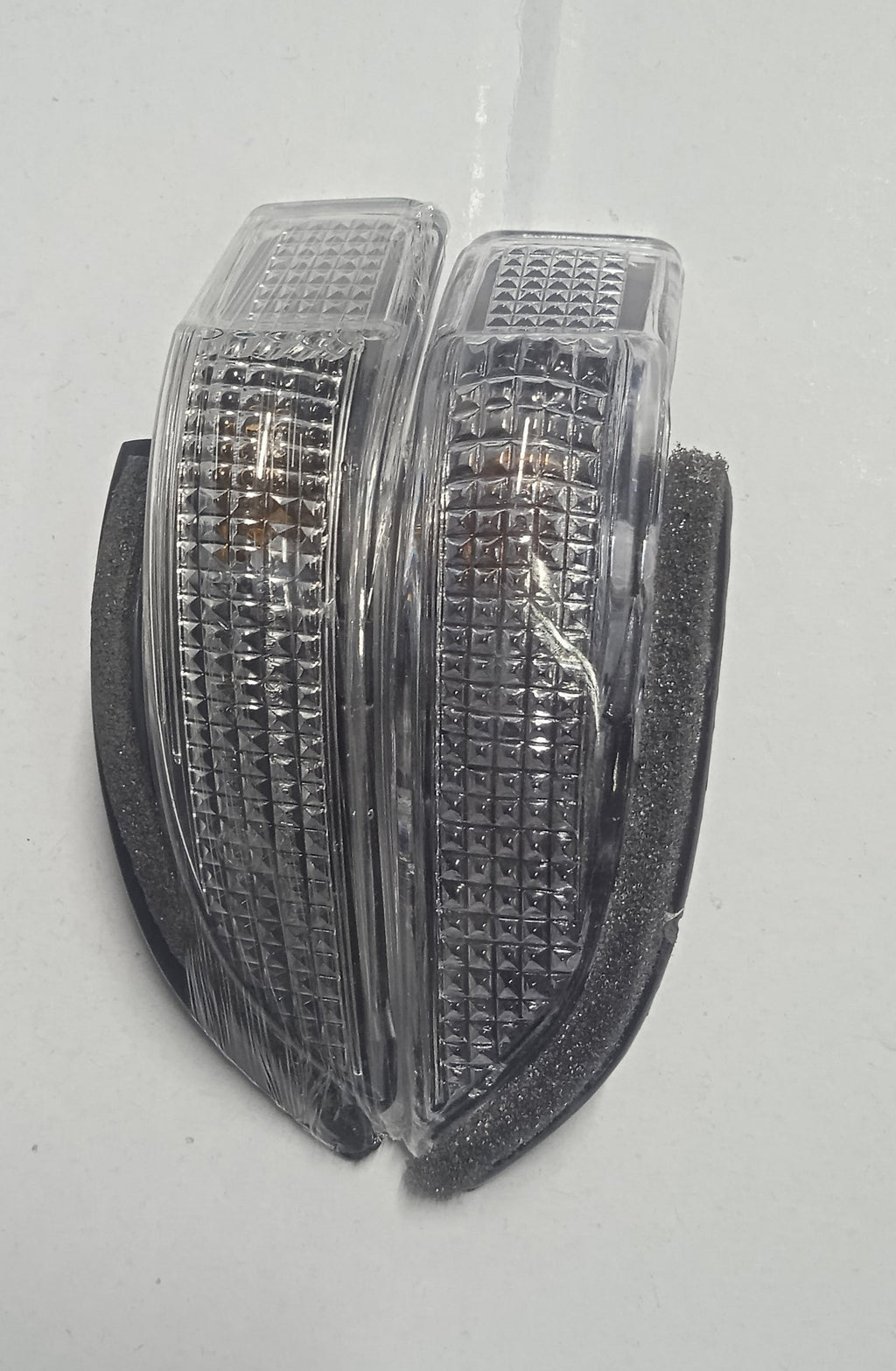 Pair of clear plastic reflectors on a white background