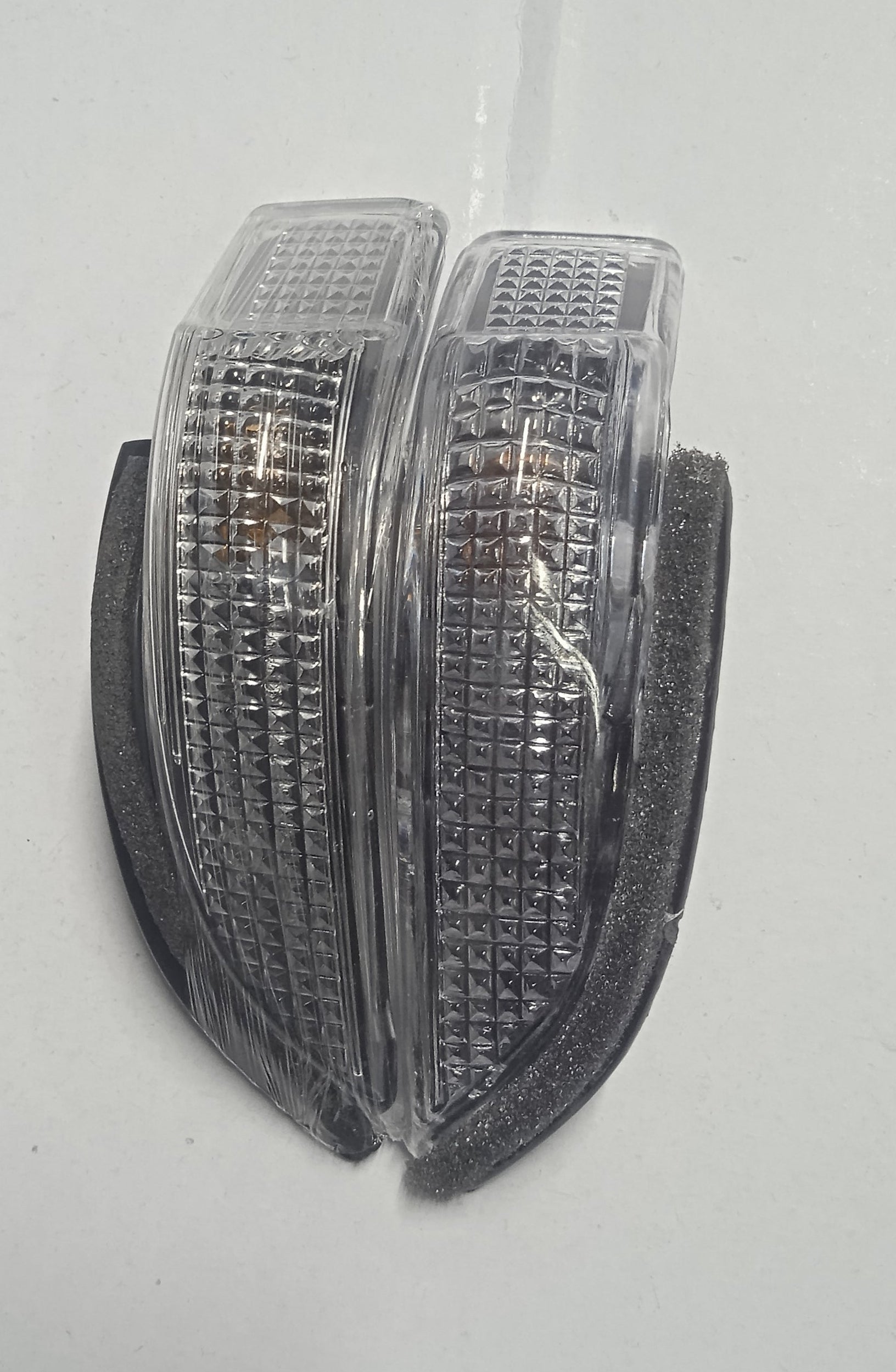 Pair of clear plastic reflectors on a white background