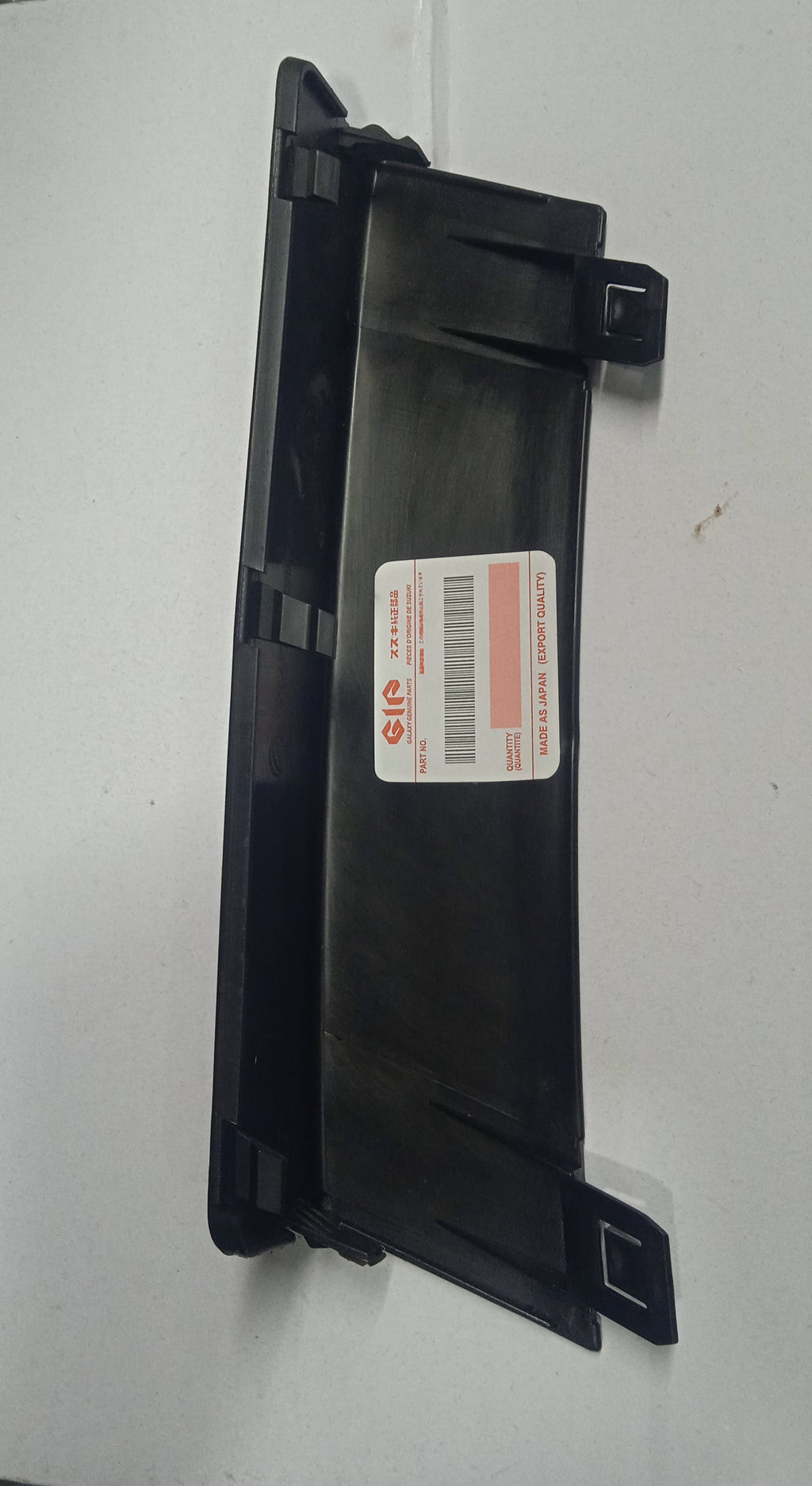 Black plastic component with a label on a white background