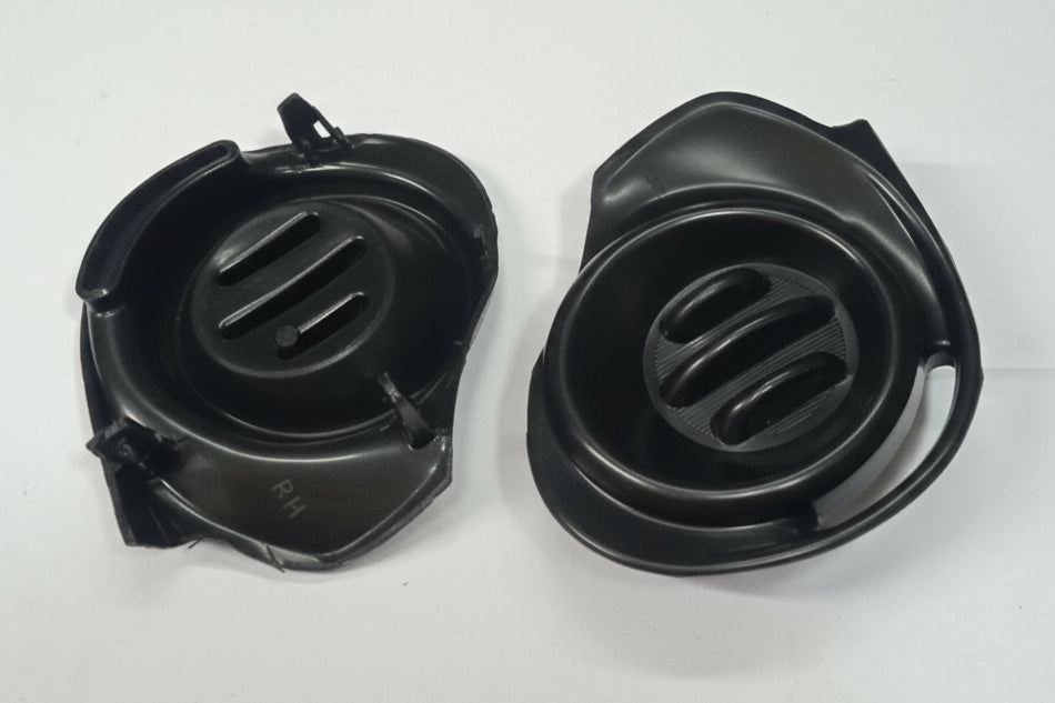 Two black plastic components with slotted design on a white background