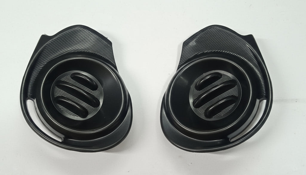 Two black plastic components with slotted designs on a white background