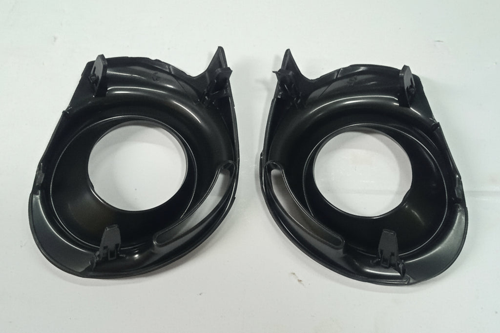 Two black plastic car speaker grills on a white background