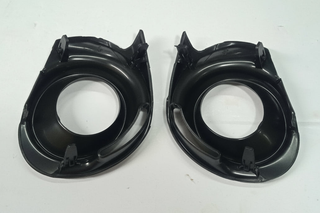 Two black plastic car speaker grills on a white background