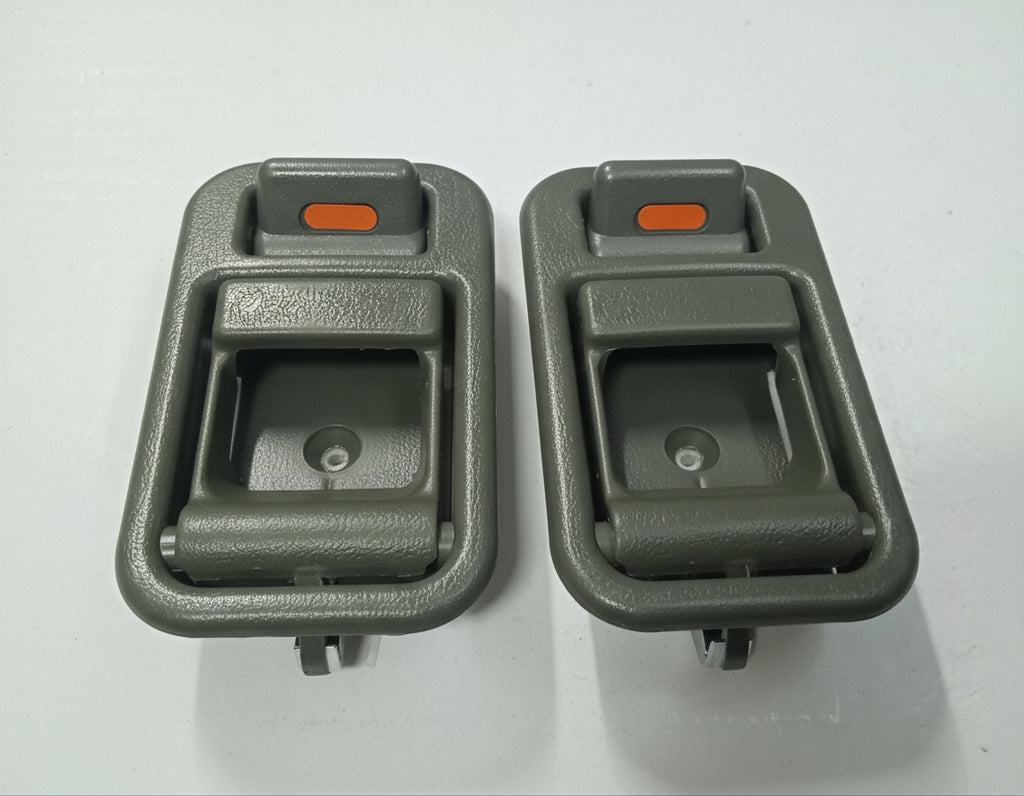 Two gray car interior door handles on a white background