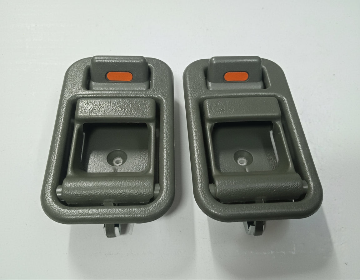 Two gray car interior door handles on a white background