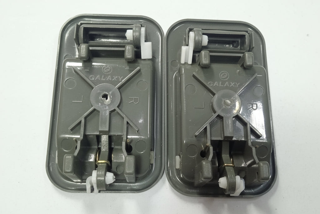 Two gray plastic components with metal gears on a white background