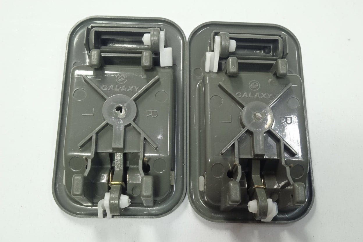 Two gray plastic components with metal gears on a white background