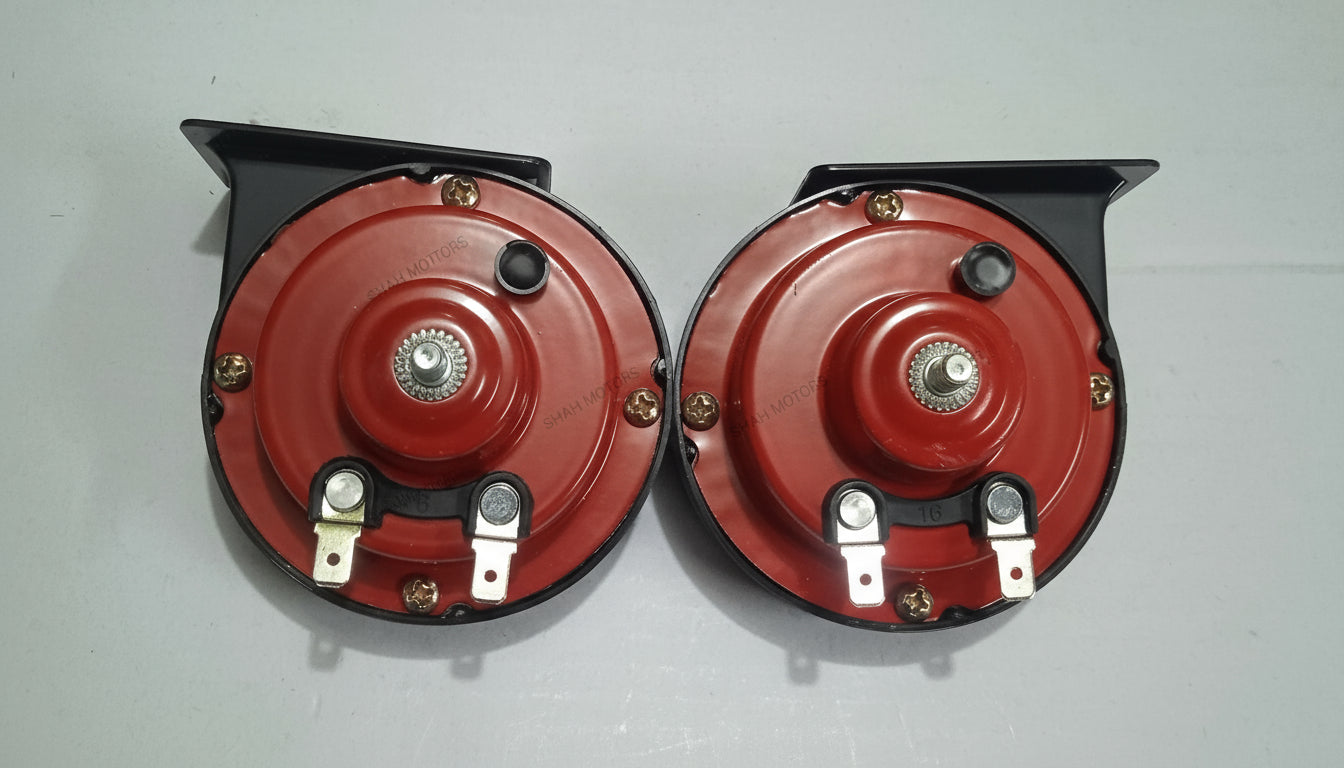 Two red car shock absorbers on a light gray background