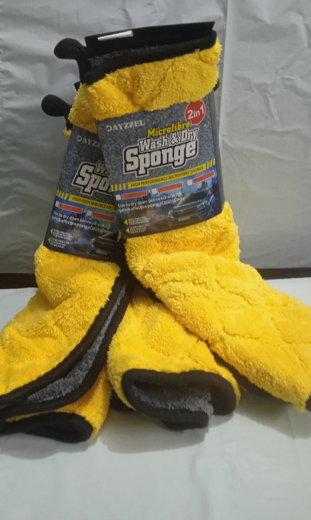 Yellow microfiber cleaning sponge with black handle on a white background