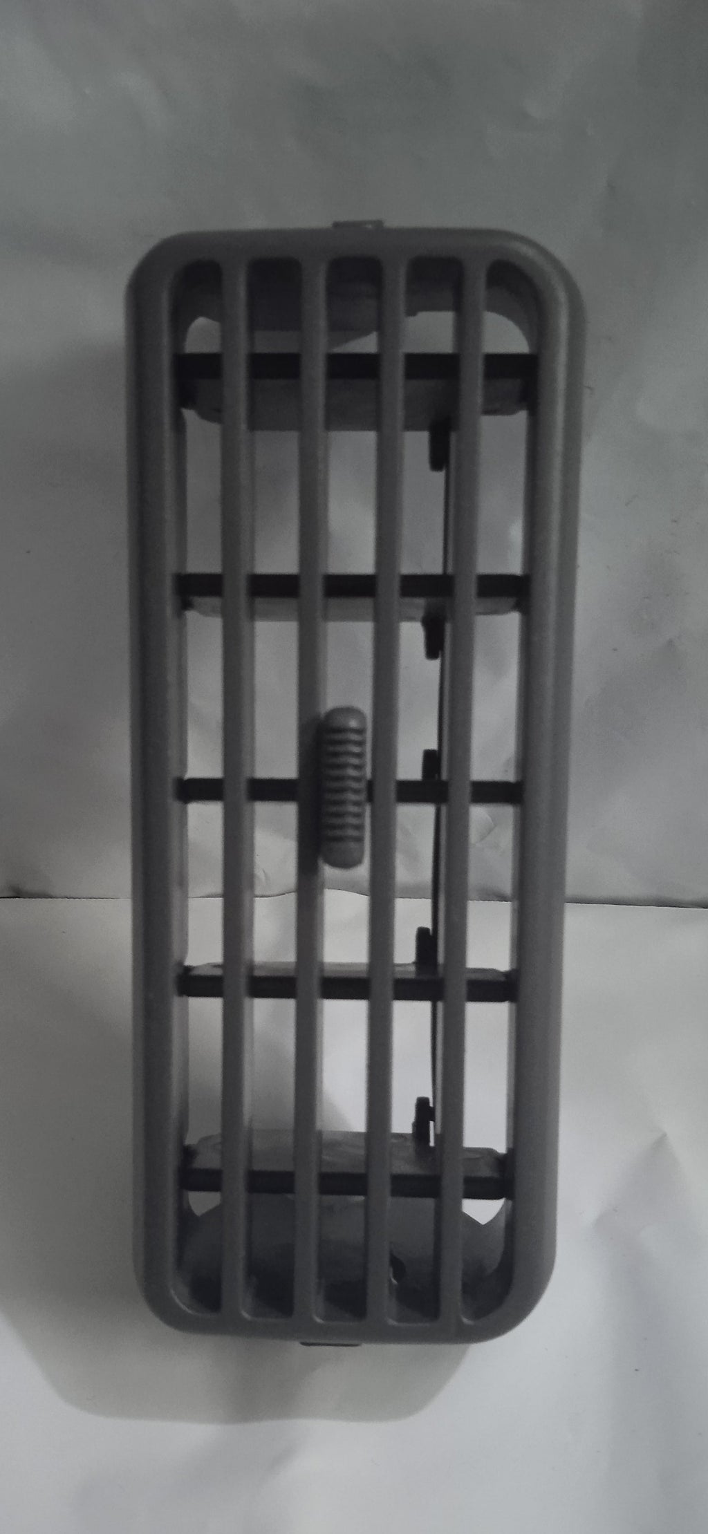 Gray plastic grid with a small screw on a white background