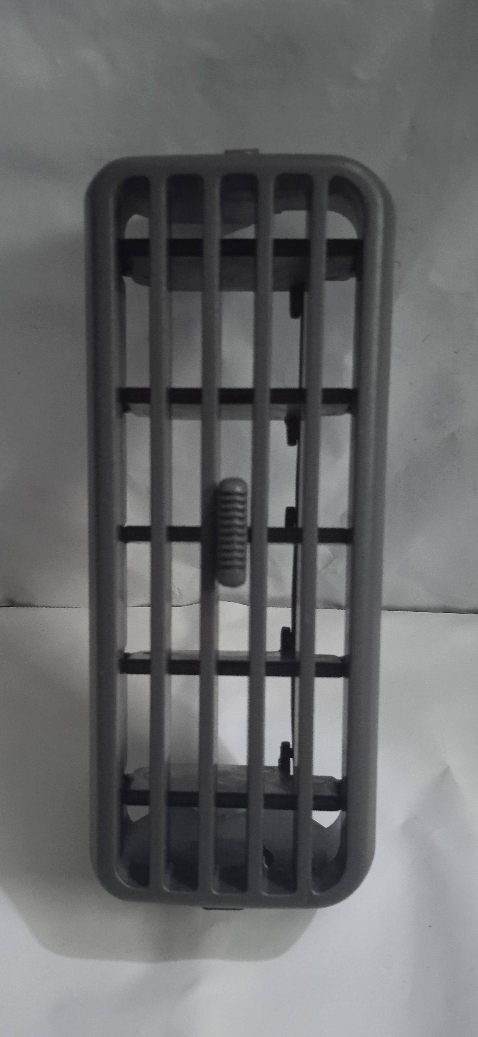 Gray plastic grid with a small screw on a white background