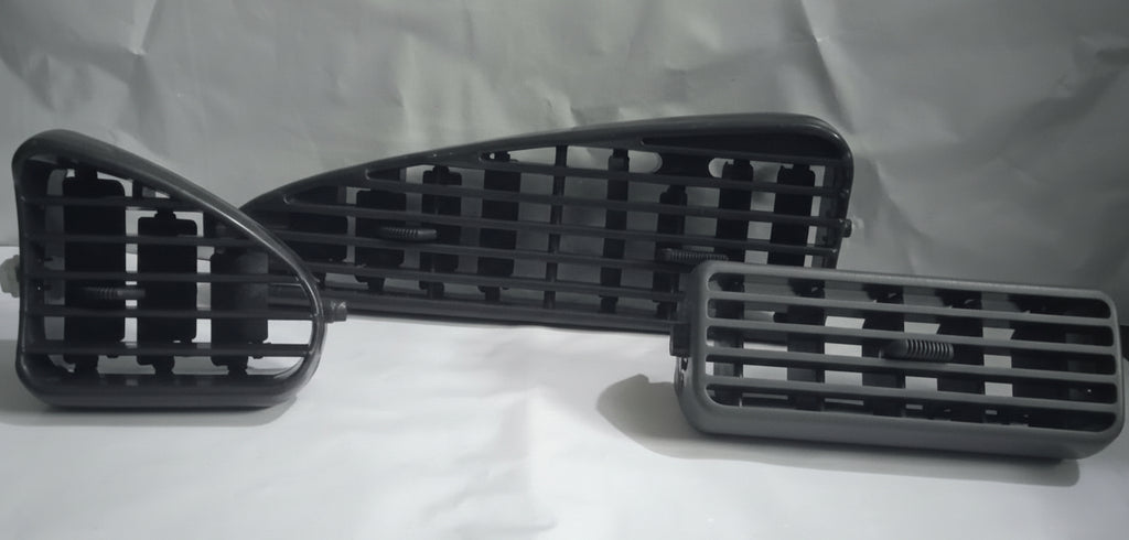 Three black car grille components on a white background
