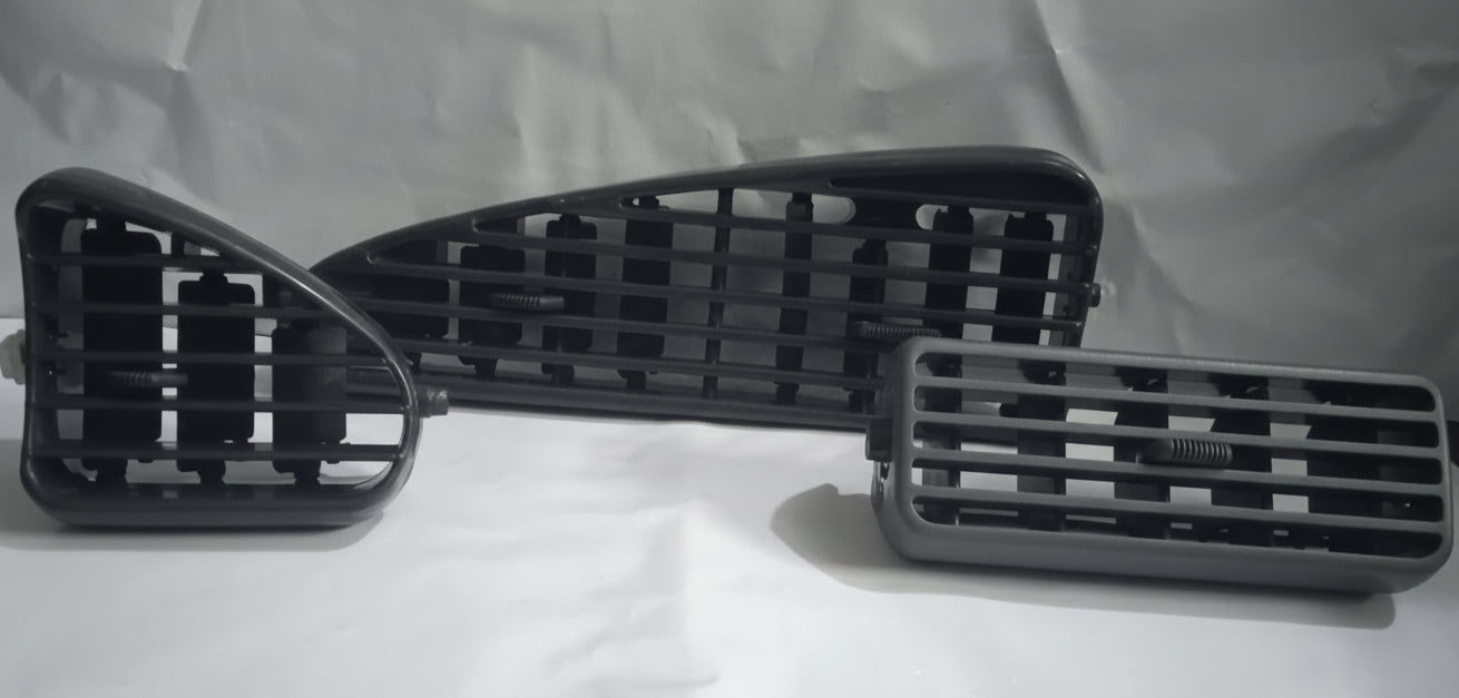 Three black car grille components on a white background