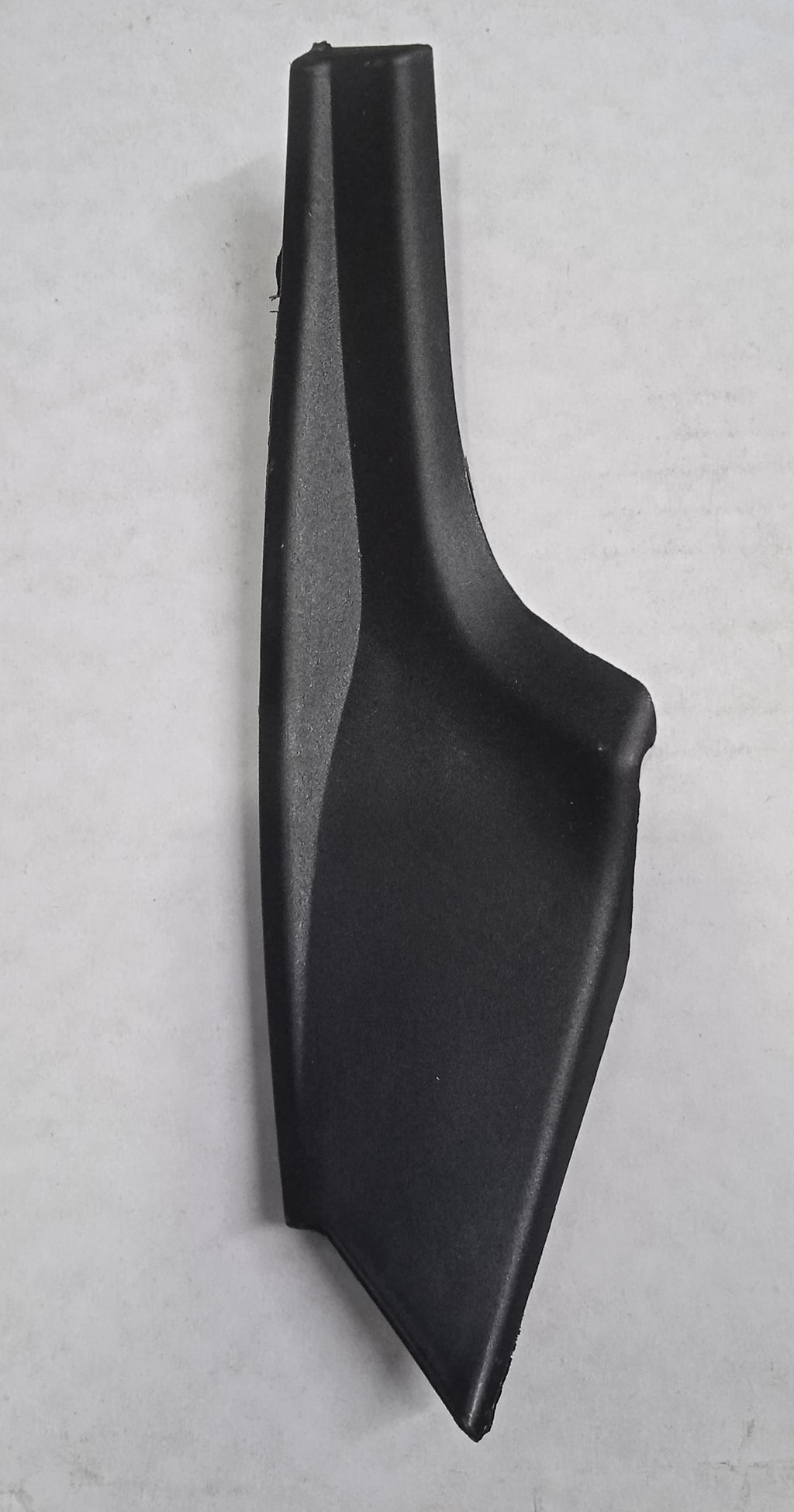 Black plastic car interior component on a gray background