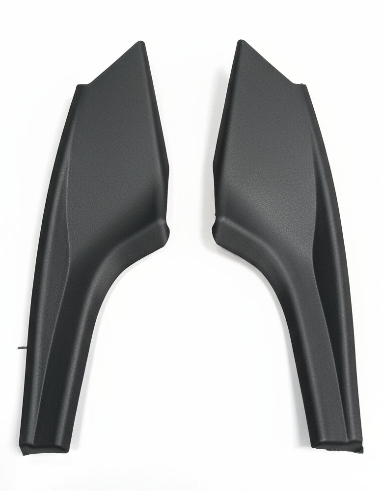 Two black plastic car parts on a light gray background